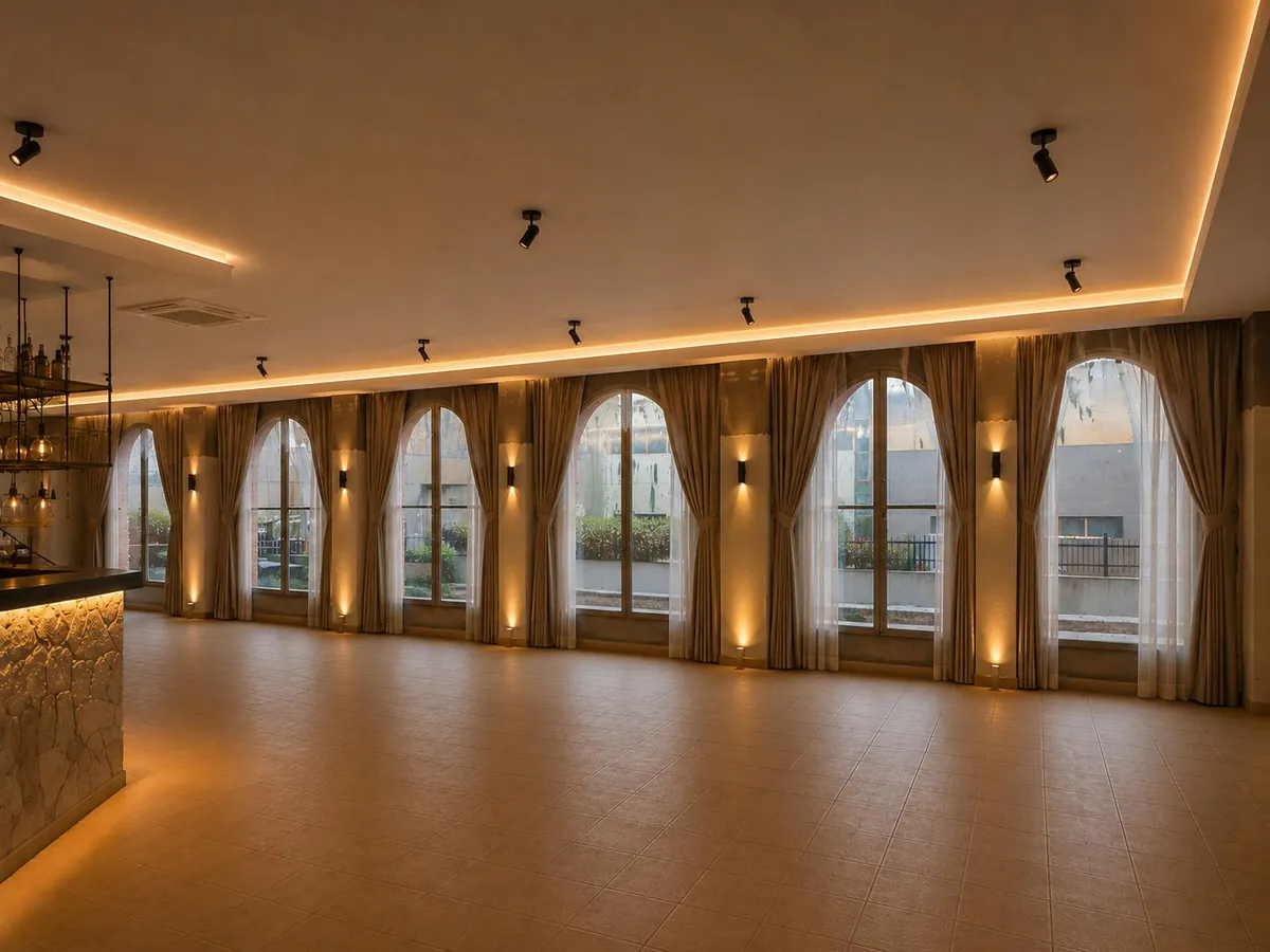 Ventanales en arco con cortinas y luz cálida en la sala para eventos privados en Riudoms